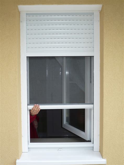 Egy modern ház ablakán szúnyoghálóval ellátott redőny